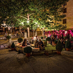 Uno stand dove le persone si rilassano e bevono un calice di vino.